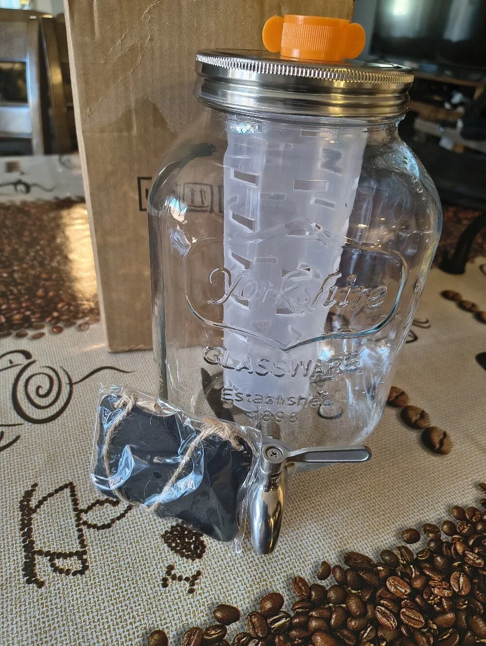 Glass Beverage Dispenser with Orange Infuser Lid and Silver Spigot